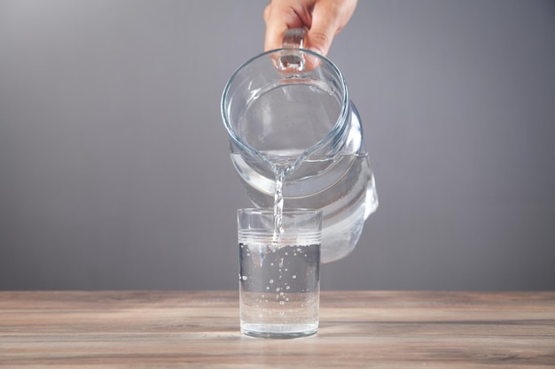 Mannenhand water gieten in glas Gezonde drank