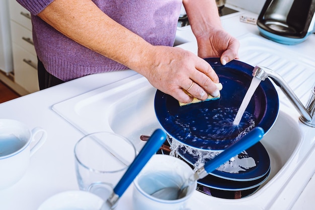 mannenhanden afwassen in gootsteen met afwasmiddel