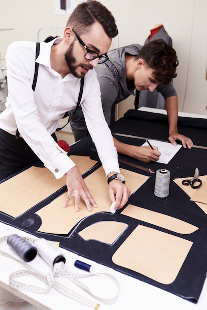 Mannenmodeontwerpers die in atelier werken