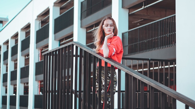 Mannequin draagt rode hoodie met de inscriptie los angeles poseren in de stad bij parking Mode stedelijke outfit Casual alledaagse kledingstijl