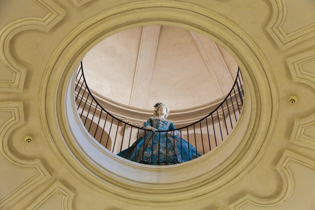 Mannequin dressed in old fashion (18th century). Interior of an old Italian palace.