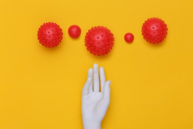 Mannequin hand and virus strain on yellow background. covid-19. top view