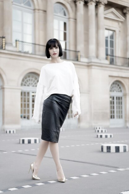 Mannequin in witte blouse en leren rok. Vrouw met rode lippen make-up in Parijs, Frankrijk. Sensuele vrouw met donkerbruin haar. Schoonheid meisje met glamour look. Mode schoonheid en uiterlijk. Zakelijk succes