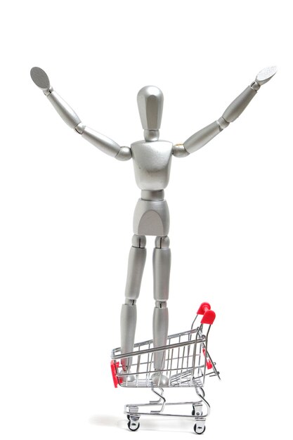 Mannequin stand shopping cart and rejoices with his hands raisedconcept of joy of going supermarket and shopping