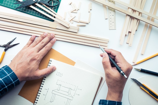 Mannetje bezig met werktafel met balsahout materiaal