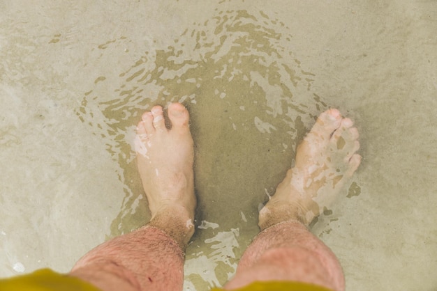 Mans blootsvoets in water bovenaanzicht