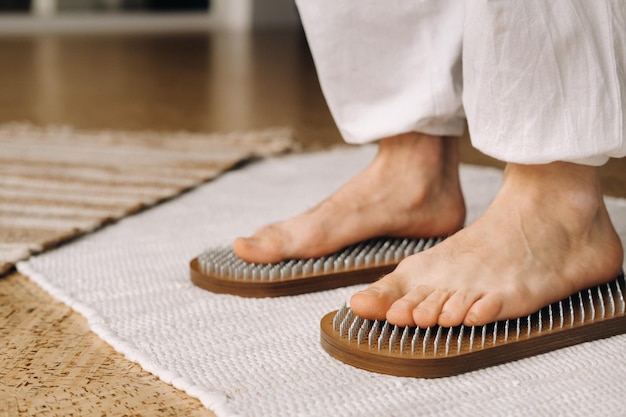 The mans feet are next to boards with nails Yoga classes