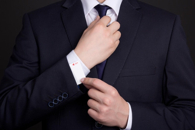 Mans hand hiding ace in business suit sleeve