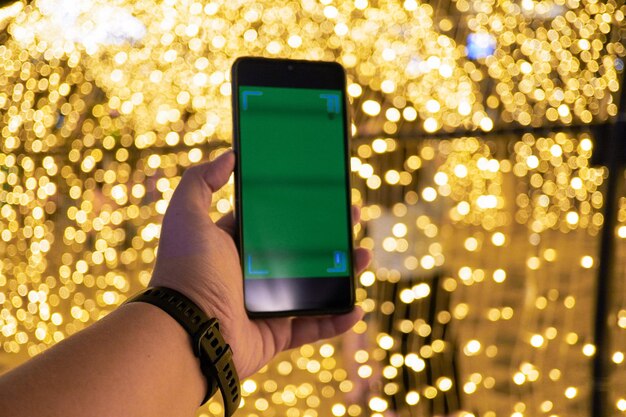 a mans hand holding a smartphone is recording a video to immortalize the moment