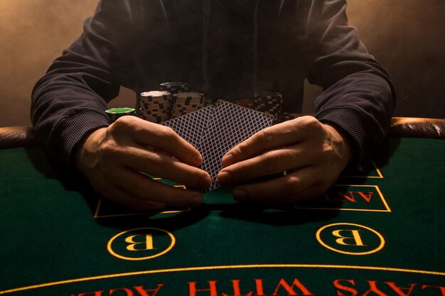 Foto mans hand met speelkaarten close-up casino kaartspel chips op tafel speelkaarten poker ch...