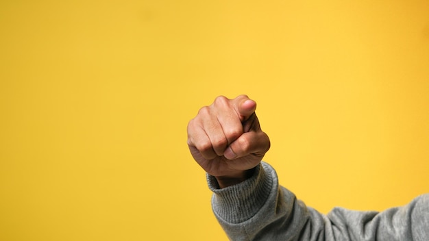 Photo mans hand pointing finger at camera on yellow background