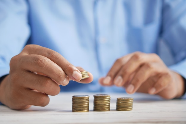 Mans hand putting stack of coins