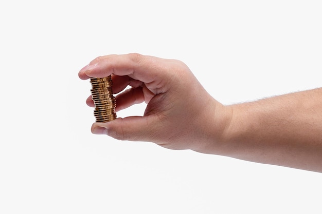 Mans hand and a stack of gold coins isolated on a white background