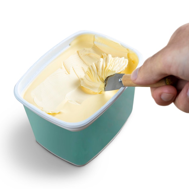 흰색 배경에 파란색 그릇에 버터 칼로 마가린을 복용하는 손