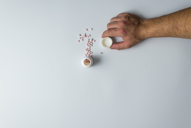 Photo mans hand with pills on white background