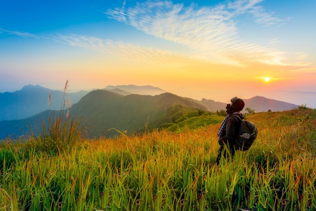 Mans silhouette on sunset mountains backdrop