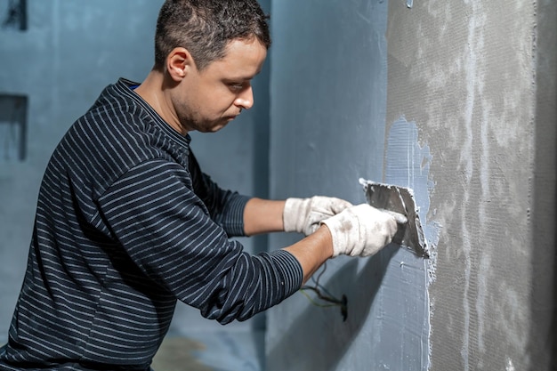 Manual application of waterproofing to the wall on the construction site