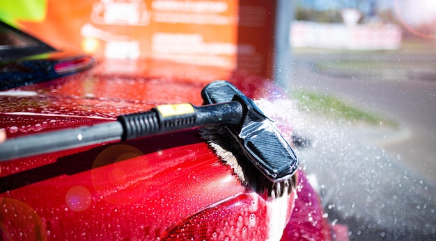 manual car wash with foam brush red body