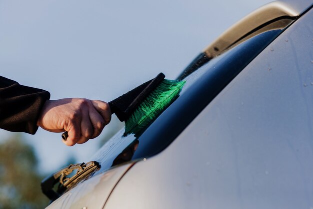 Manual car washing with a brush in the open air