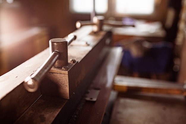 Manual flexible machine close-up. old classic vintage retro\
machine part mechanical construction press for sheet metal steel\
processing