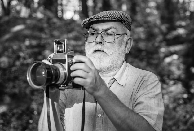 Foto impostazioni manuali hobby della pensione fotografo esperto vecchio fotografa la natura pensionamento del cameraman fotografo professionista foto paesaggistica della natura riprese del vecchio fotografo crea una cornice perfetta