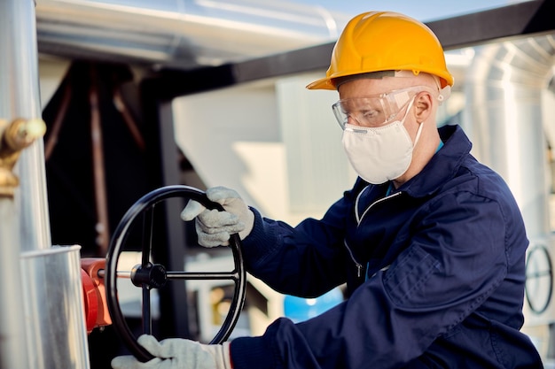 Operaio manuale con valvola di chiusura della maschera protettiva in cantiere