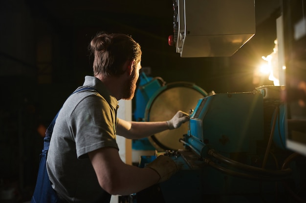 Manual worker working at the lathe