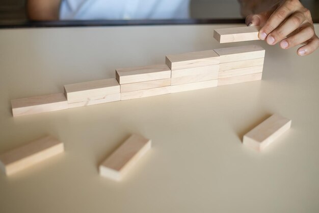 Foto organizzare manualmente l'impilamento dei blocchi di legno come una scala a gradini concetto di percorso di carriera per lo sviluppo di affari di successo spazio di copia