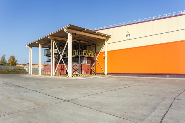 Manufacture building of modern waste recycling processing plant in orange style Separate garbage collection Recycling and storage of waste for further disposal