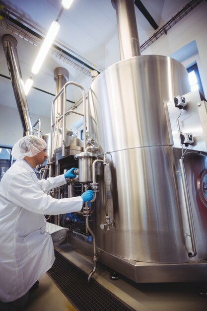 Manufacturer kneeling while working in brewery