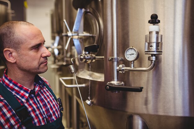 Manufacturer looking at pressure gauge in brewery