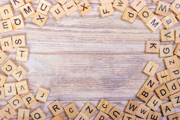 Many abc education cube scattered on wooden table background