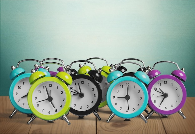 Many alarm clocks on wooden table