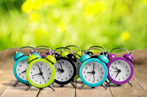 Many alarm clocks on wooden table