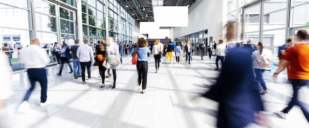 Photo many anonymous people go to a bright trade show show