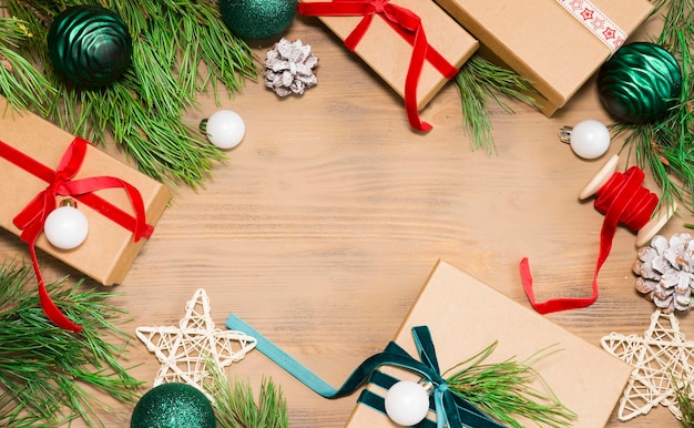 Many assorted gift boxes and pine branches on wooden background