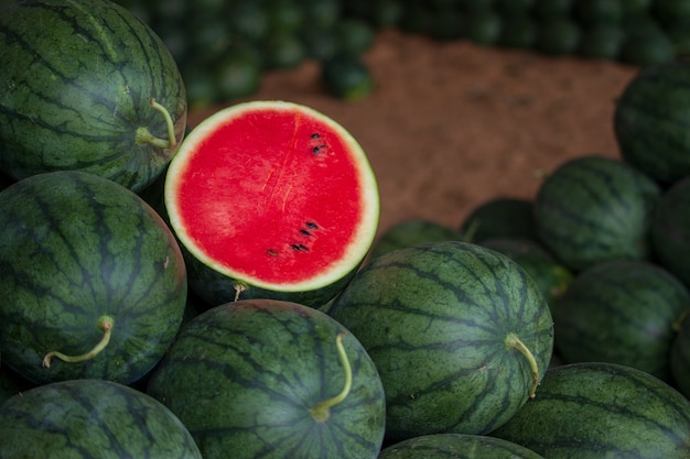 Many big sweet green watermelons and one cut watermelon