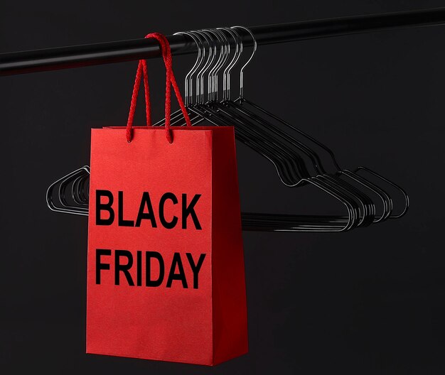 Множество черных вешалок и красная сумка с надписью BLACK FRIDAY на стержне. Концепция магазина. Черная пятница. распродажа