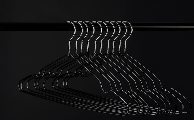 Photo many black hangers on a rod. store concept. black friday. sale