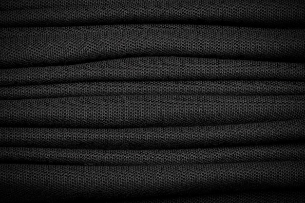 Many of black shirt background. Dark textile material.