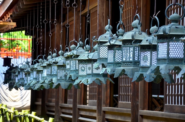 Many black steel lanterns hanging around at wooden church of Kasuga Shrine in Nara Japan