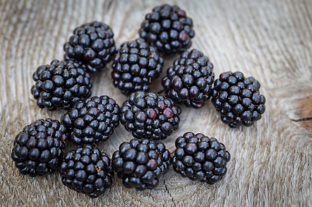 Many blackberries resting on the wooden table