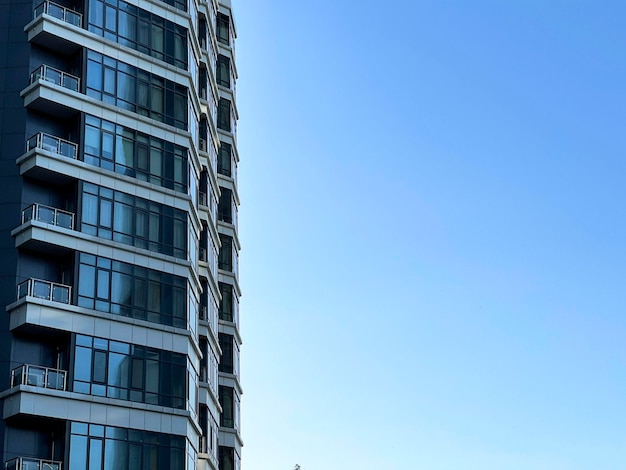 Many blue glass windows of a modern apartmetn building copy space