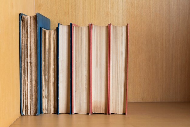 Photo many books are placed at library shelves.