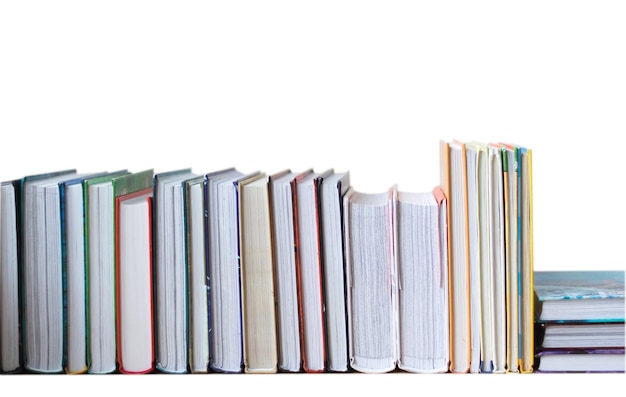 Many books in a row stand on the table on Isolated white background