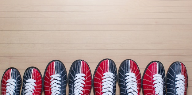 Molte scarpe da bowling sul pavimento.