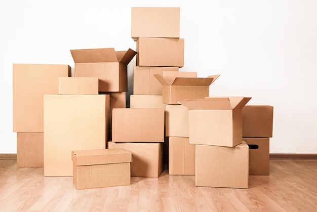 Many boxes piled in a pile in a home room, concept of moving to a new house