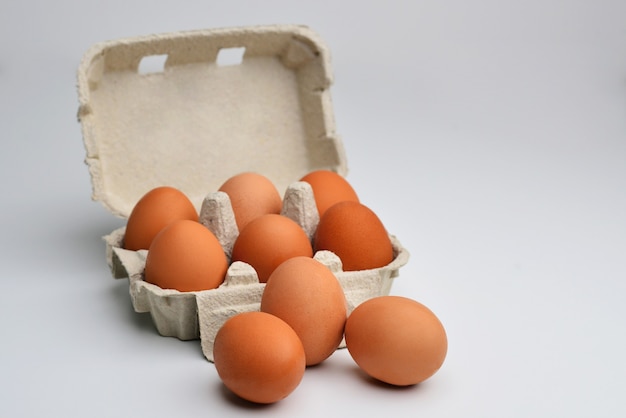 Many brown eggs isolated on white chicken eggs are fresh in a cardboard package