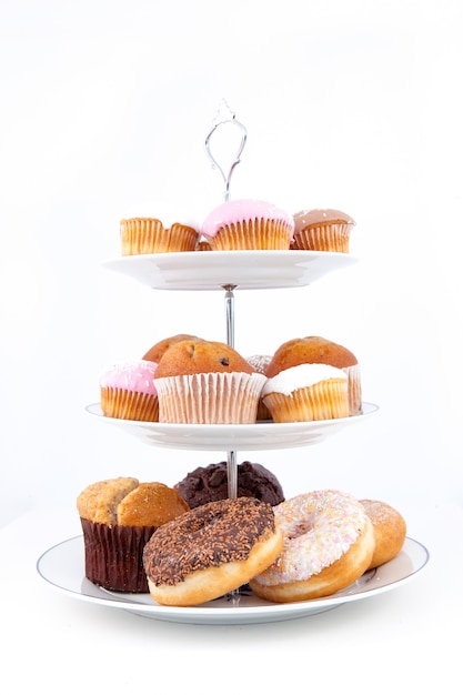 Many cakes placed on three white plates