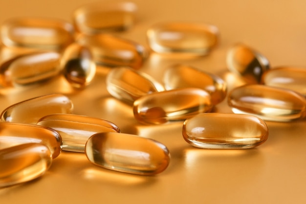 Many capsules Omega 3 on yellow background. Close up, high resolution product. Health care concept.